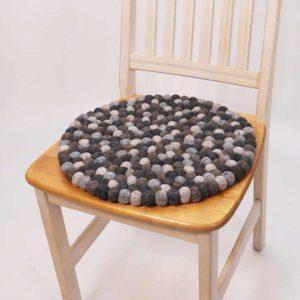 Harmaa sävyinen huopapalloista valmistettu istuinalunen.